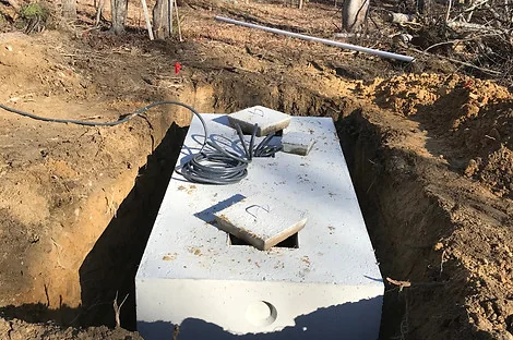 Concrete septic tank in an excavation with electrical cables running to the lid Concrete septic tank in an excavation with electrical cables running to the lid