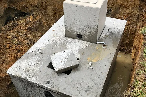Concrete septic tank with a tall riser and the access lid slid open