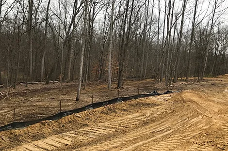 Silt fence along a graded wooded lot with bare soil Silt fence along a graded wooded lot with bare soil